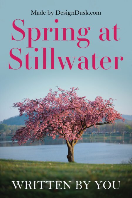 A flowering pink tree stands beside a calm lake beneath a pale blue spring sky.